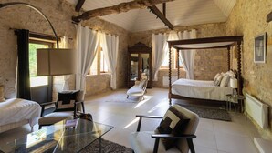 A room with a bed, a chair, a glass table, and a mirror. - Historic manor house with a pool, garden, and restaurant. Breathtaking view. (Le Vigan-en-Quercy)