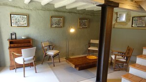 A room with a wooden desk, two chairs, a small table, and artwork on the walls. - Historic manor house with a pool, garden, and restaurant. Breathtaking view. (Le Vigan-en-Quercy)