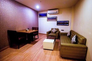A room with a dining table, two sofas, and a coffee table.
