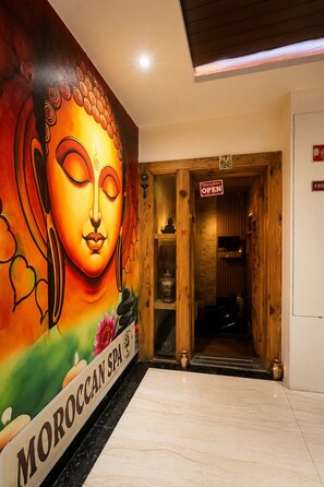 A spa entrance with a large Buddha mural, a wooden door, and a sign indicating the spa name. - Kalptaru Hotel Nepalganj (Nepalgunj)