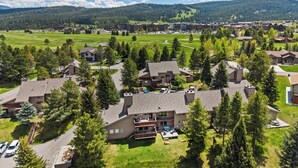 Ein Wohngebiet mit Häusern, einem Golfplatz und einer Bergkulisse.