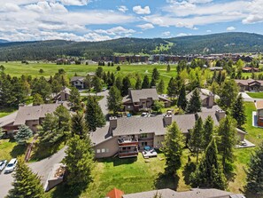 Ein Wohngebiet mit Häusern, einem Golfplatz und einer Bergkulisse.