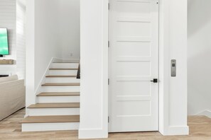 A staircase leading to a white door with a doorbell. - 5 BR NEW 2026 BUILD | 5 O'Clock Shadow | Gulf Views | Sleeps 12 (Inlet Beach)