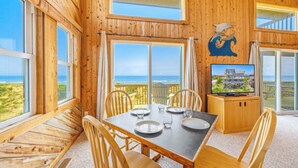 A wooden interior with a dining table, chairs, and a television. - Oceanfront, Dog Friendly Home in Avon with Boardwalk to the Beach (Avon)