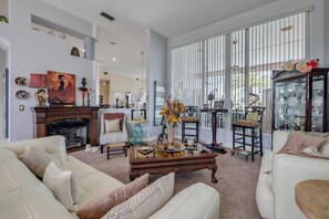 Ein Wohnzimmer mit Kamin, Couchtisch und Bücherregal.