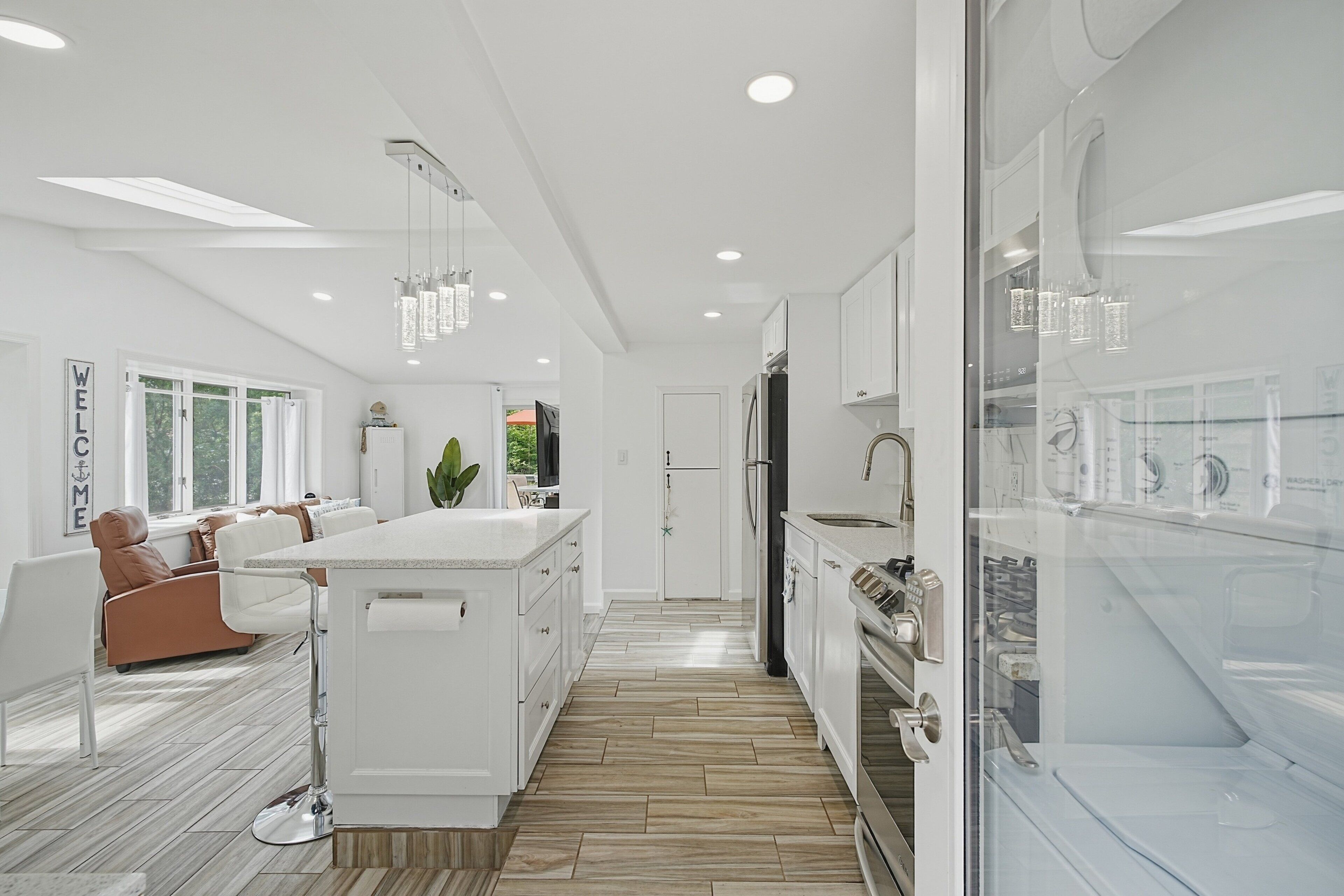 Una cocina moderna con armarios blancos, una isla central y un horno empotrado.