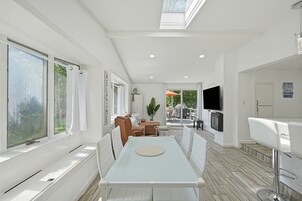 Una cocina moderna con comedor, ventanas amplias y televisión.