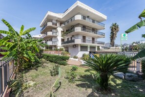 A multi-story residential building with balconies, a pharmacy, and a dispensary. - Apartment 'Naxos Sea View' with Sea View, Wi-Fi and Air Conditioning (Naxos)