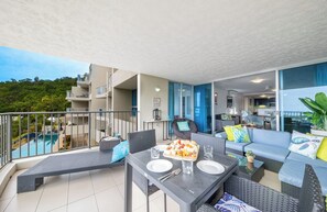 Ein Balkon mit Esstisch, Stühlen und einer Couch.