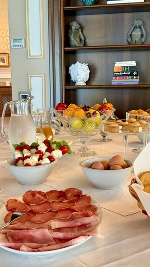 A breakfast buffet with various food items, including fruits, eggs, and meats. - Villa Lena Puglia (Oria)