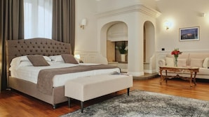 A bedroom with a large bed, a sofa, a coffee table, and a painting on the wall. - Villa Lena Puglia (Oria)