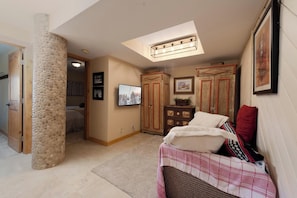 Ein Schlafzimmer mit Bett, Kleiderschrank, Fernseher und Dachfenster.