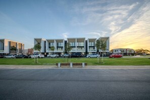 Un bâtiment moderne avec un parking et des voitures.