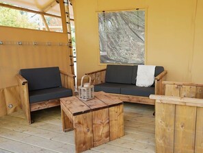 Ein Holzinnenraum mit zwei Sofas, einem kleinen Tisch und einem großen Fenster mit Blick.