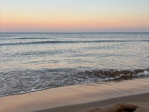 Ein Strand mit Wellen und blauem Himmel.