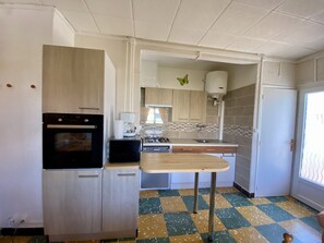 Eine Küche mit Herd, Backofen, Mikrowelle und Kaffeemaschine.