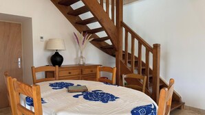 Ein Schlafzimmer mit einem hölzernen Bett, einem Nachttisch, einer Lampe und einer Vase mit getrockneten Blumen.