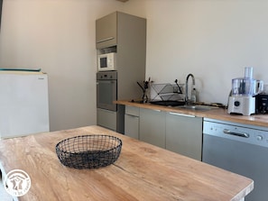 Eine Küche mit Mikrowelle, Backofen, Spüle und Geschirrspüler.