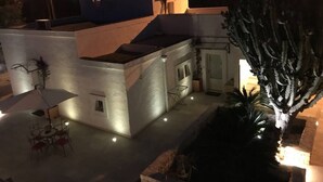 Eine Dachterrasse mit Kaktee, einem kleinen Tisch und Stühlen.