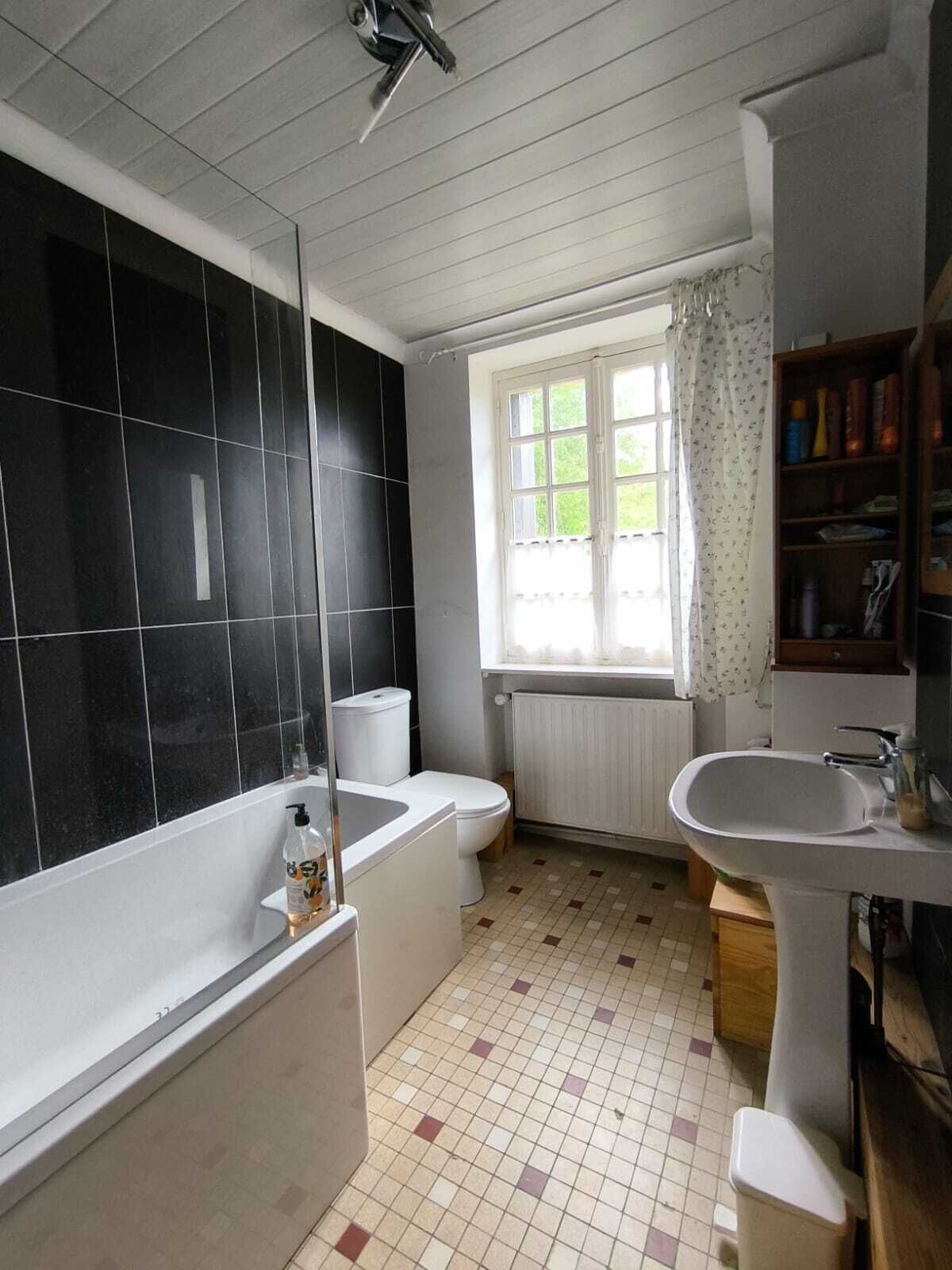 Een badkamer met een bad, toilet en wastafel.