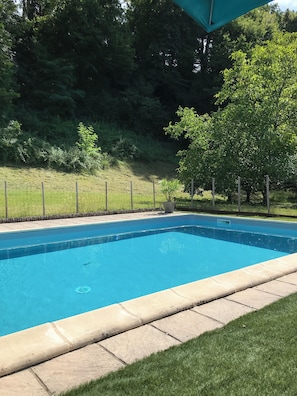 A rectangular swimming pool with a tiled edge, surrounded by a grassy area and a fence. - 10 km south of Sarlat, first floor of a Périgord-style house (Sainte-Mondane)