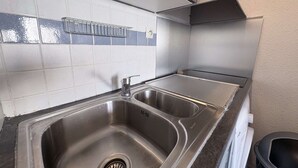 Keittiössä on kaksi ruostumattomasta teräksestä valmistettua pesuallasta, laatoitettu välitila ja ruostumattomasta teräksestä valmistettu liesituuletin.