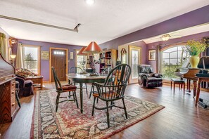 A dining area with a table, chairs, and a piano. - CABIN - Pet Friendly, Lake View, Patio & Deck, Trails (Cokato)