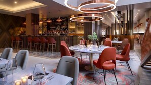 A modern restaurant with round tables, red chairs, and a bar area in the background. - Clayton Hotel St Andrew Square, Edinburgh (Edinburgh)