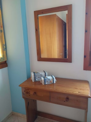 A wooden dresser with drawers, a mirror above it, and two small boxes on the dresser. - Studio 1 Apartment with Sea View and Balcony (Karpathos)