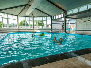 An indoor swimming pool with clear water, a tiled floor, and a covered roof structure. - Holiday Home in Noordwijk With Terrace (Noordwijk)