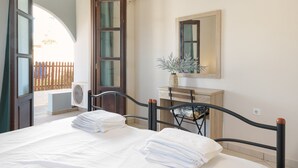 Un dormitorio con cama, mesita de noche, espejo y ventana.