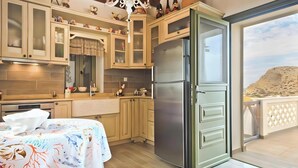 Uma cozinha com armários de madeira, uma geladeira de aço inoxidável e uma mesa com toalha de mesa florida.