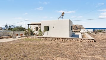 Un bâtiment moderne, de plain-pied, doté d’un toit plat, d’une antenne parabolique sur le toit et de fondations en pierre.
