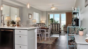 A kitchen with a dining area, a ceiling fan, and a view of the outdoors. - ☀️ Short Walk to Beach - Summerhouse 206 – Brown Eyed Girl ☀️ (Mexico Beach)