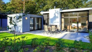 A modern house with a patio, a small garden, and a large glass door leading to a living area. - Holiday Home in Nijkerk With Terrace (Nijkerk)
