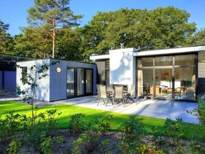 A modern house with a patio, a small garden, and a large glass door leading to a living area. - Holiday Home in Nijkerk With Terrace (Nijkerk)