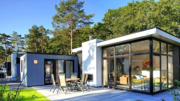 A modern house with a patio, a small shed, and a glass-enclosed living area. - Holiday Home in Nijkerk With Terrace (Nijkerk)