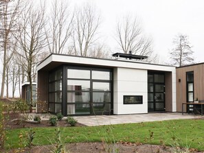 A modern house with large glass windows, a flat roof, and a patio area. - Holiday Home in Nijkerk With Terrace (Nijkerk)