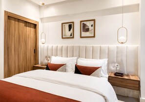 A modern bedroom with a large bed, wooden wardrobe, bedside tables, and two framed artworks on the wall. - Modern 2-Bedroom Apartment in Central Gueliz Near Carré Eden (Marrakesh)