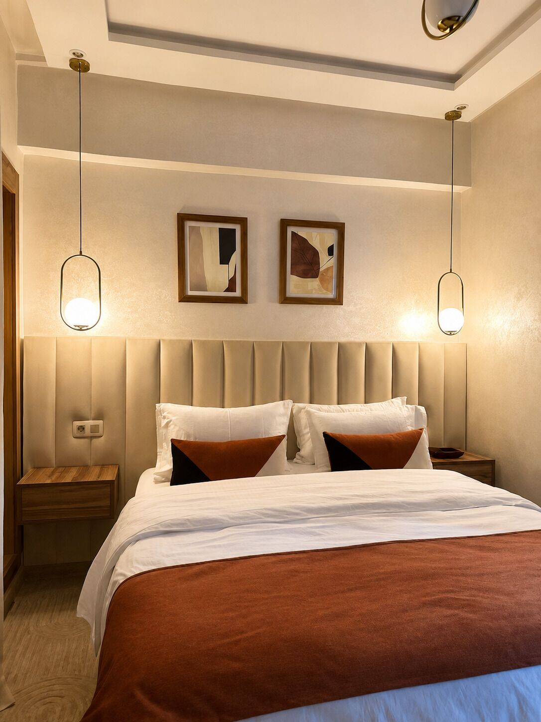 A hotel room with a bed, two bedside tables, a headboard, and two wall-mounted light fixtures.