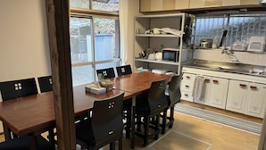 A kitchen with a dining table, chairs, and a window.