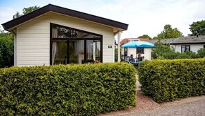 A single-story building with a flat roof, large windows, and a door. - Holiday Home for 5 People (Noordwijk)