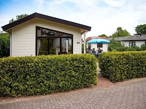 A single-story building with a flat roof, large windows, and a door. - Holiday Home for 5 People (Noordwijk)