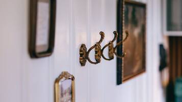 A wall with a series of hooks and framed pictures.