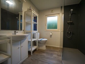 A bathroom with a sink, toilet, shower, and a window with frosted glass. - Holiday Home in Velsen-zuid With Terrace (Velsen-Zuid)