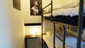 A bunk bed room with a single bed on the bottom bunk and a nightstand with a lamp. - Holiday Home in Velsen-zuid With Terrace (Velsen-Zuid)