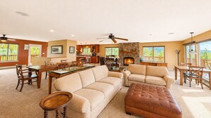 A spacious living room with a fireplace, a dining area, and a kitchen.