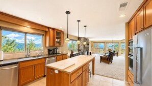 A spacious kitchen with wooden cabinets, a large island, and a view of the mountains.