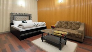 Een kamer met een bed, een bank en een bijzettafeltje.