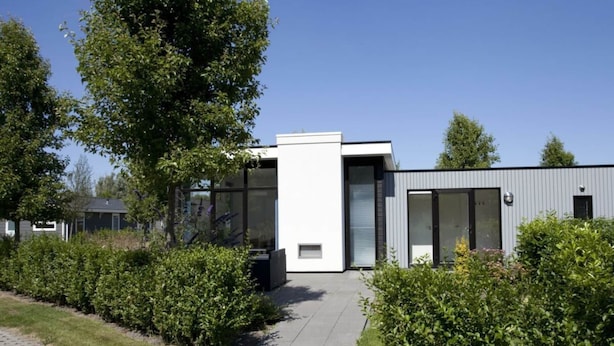 A modern building with a flat roof, large windows, and a paved pathway leading to the entrance. - Cube Exclusive 4 (Velsen-Zuid)